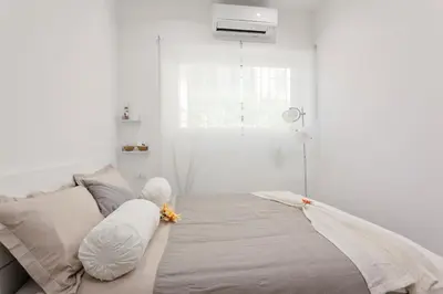 a white bedroom with a large bed with pillows at The Apartment Trastevere - Ba.home in Rome