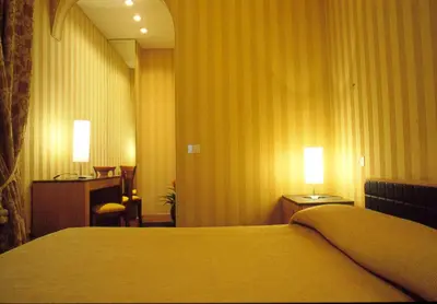a hotel room with a bed and two lamps on tables at Orange Garden Guest House in Rome