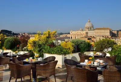a patio with tables and chairs with a view of the city at Orange Garden Guest House in Rome