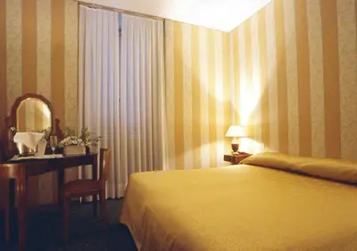 a bedroom with a bed and a desk and a mirror at Orange Garden Guest House in Rome