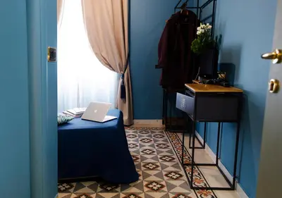 a blue room with a table with a laptop on it at Eterna Roma in Rome