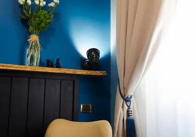 a blue room with a chair and a vase of flowers at Eterna Roma in Rome