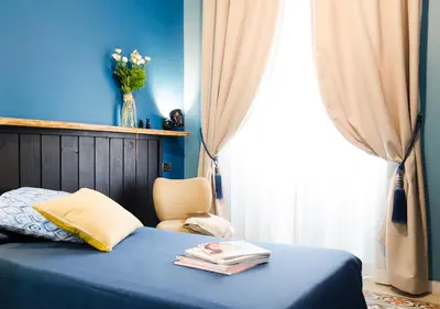 a bedroom with a bed and a chair and a window at Eterna Roma in Rome