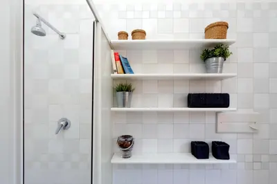 a bathroom with white shelves and a shower at Fori Imperiali Apartment in Rome