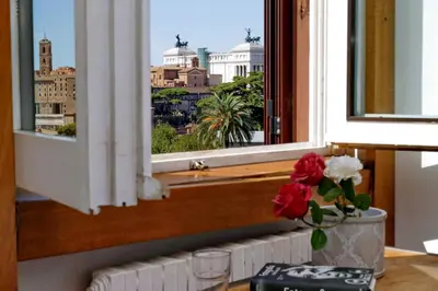 a window with a vase of flowers on a table at Fori Imperiali Apartment in Rome