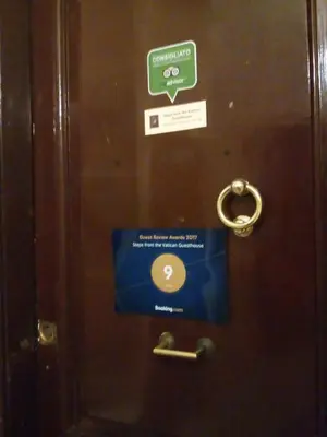 a door with a sign on it with a key at Steps from the Vatican Guesthouse in Rome