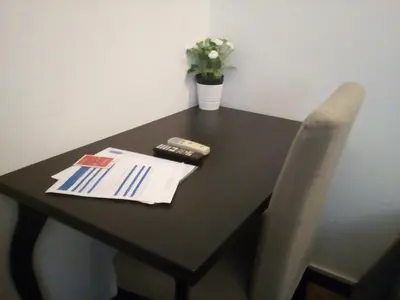 a black table with a chair and a vase of flowers at Steps from the Vatican Guesthouse in Rome