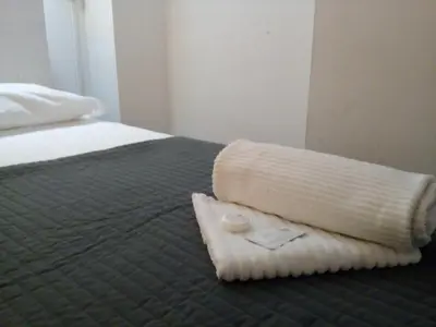 a bed with a blanket and a towel on it at Steps from the Vatican Guesthouse in Rome