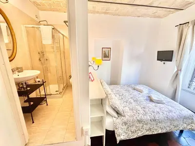 a small room with a bed and a sink at Steps from the Vatican Guesthouse in Rome
