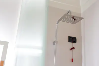 a shower in a bathroom with a white wall at Hotel The Haven Roma in Rome