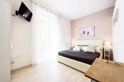 a bedroom with a bed and a tv on a wall at Saint Peter Cozy Apartment in Rome