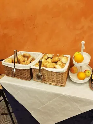 three baskets of bread and fruit on a table at Hotel Kennedy in Rome