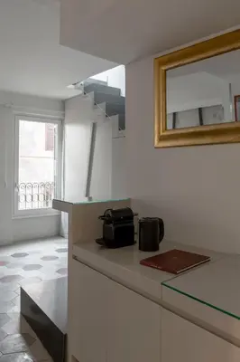 a white kitchen with a counter and a mirror at BDB Rooms Navona in Rome