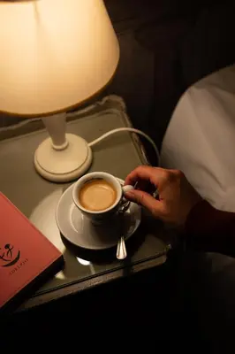 a person holding a cup of coffee on a table at BDB Rooms Navona in Rome