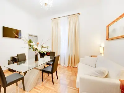a white living room with a table and a white couch at Queen Palace Suites in Rome