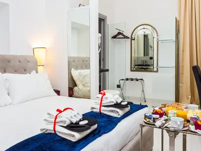 a hotel room with a bed with a tray of food at Queen Palace Suites in Rome