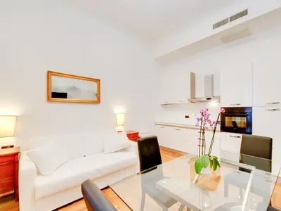 a living room with a glass table and a white couch at Queen Palace Suites in Rome