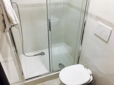 a bathroom with a shower with a toilet and a glass shower door at Favola Romana - Guest House in Rome