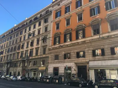 a large building with cars parked in front of it at Favola Romana - Guest House in Rome
