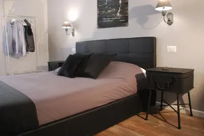 a bed with a black headboard and a side table at SuityRHome RioneMonti118 in Rome