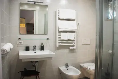a bathroom with a sink and a toilet and a mirror at SuityRHome RioneMonti118 in Rome