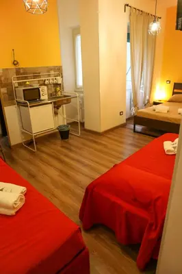 a living room with two red beds and a kitchen at Nonna's house in Rome