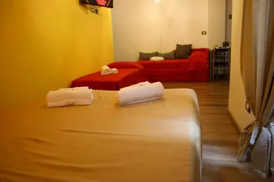 a room with two beds and a red couch at Nonna's house in Rome