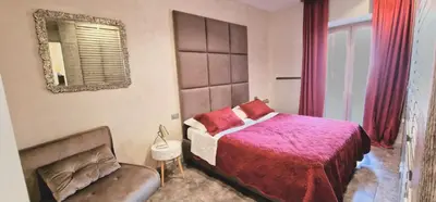 a bedroom with a bed and a mirror and a couch at Fornaci Guest House in Rome