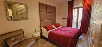 a bedroom with a bed and a chair and a mirror at Fornaci Guest House in Rome