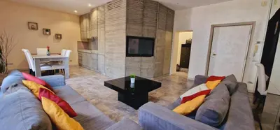 a living room with a couch and a tv and a table at Fornaci Guest House in Rome
