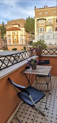 a table and chairs on a balcony with a railing at Fornaci Guest House in Rome