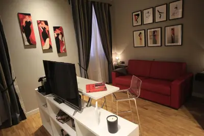 a living room with a red couch and a tv at K Rooms in Rome