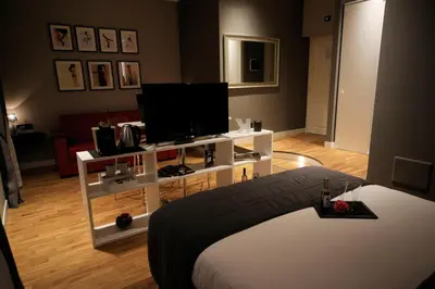 a living room with a bed and a television at K Rooms in Rome