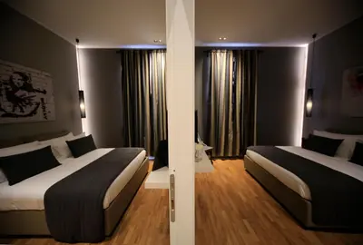 two beds in a hotel room with two windows at K Rooms in Rome