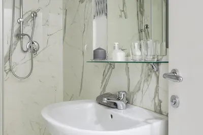 a white bathroom with a sink and a shower at Little Aurelius in Rome