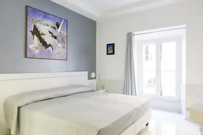 a white bedroom with a bed and a window at Little Aurelius in Rome