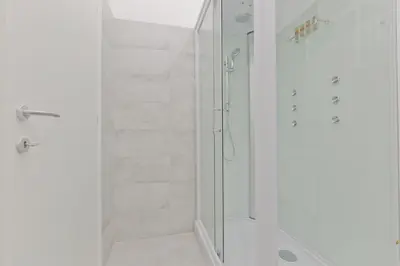 a white bathroom with a shower with a glass door at New Rome house 2 in Rome