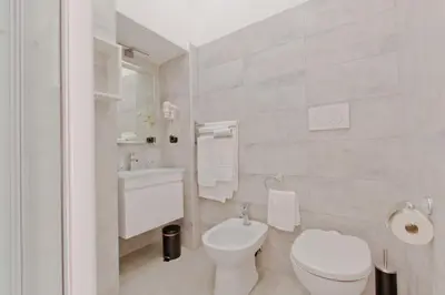 a white bathroom with a toilet and a sink at New Rome house 2 in Rome