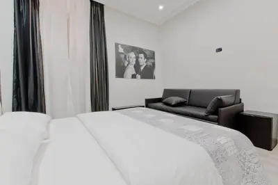 a bedroom with a white bed and a couch at New Rome house 2 in Rome