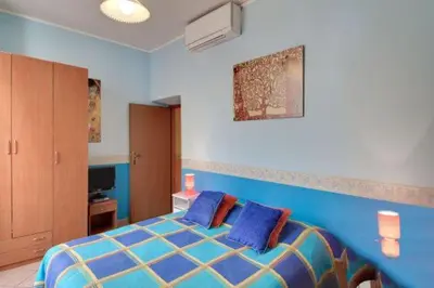 a bedroom with a blue bed with two blue pillows at La Dolce Vita Colosseum in Rome