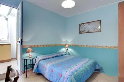 a blue bedroom with a bed and two tables at La Dolce Vita Colosseum in Rome