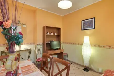a living room with a television and a table with chairs at La Dolce Vita Colosseum in Rome