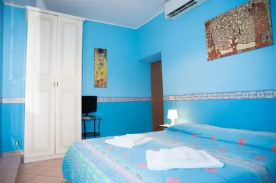 a blue bedroom with a bed with blue walls at La Dolce Vita Colosseum in Rome