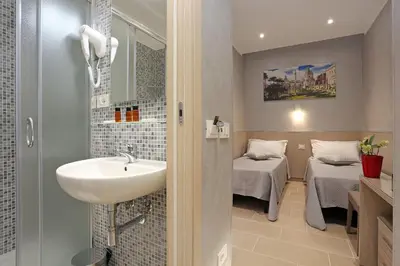a bathroom with a sink and a mirror and two beds at AdoraSuite 2 in Rome