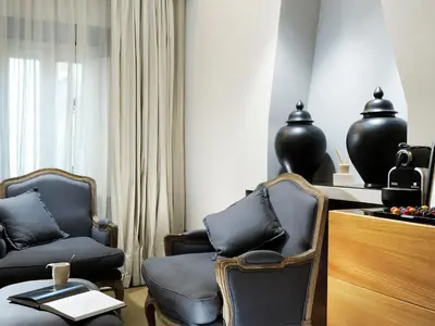 a living room with two chairs and a table at Mario De' Fiori 37 in Rome
