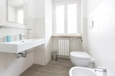 a white bathroom with a toilet and a sink at 247 Luxury Rooms Trastevere in Rome