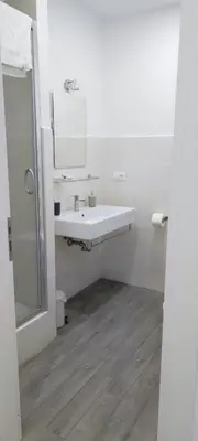 a white bathroom with a sink and a mirror at 247 Luxury Rooms Trastevere in Rome