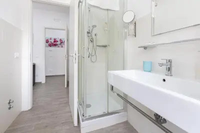 a white bathroom with a sink and a shower at 247 Luxury Rooms Trastevere in Rome