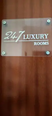 a sign for luxury rooms on a wooden wall at 247 Luxury Rooms Trastevere in Rome