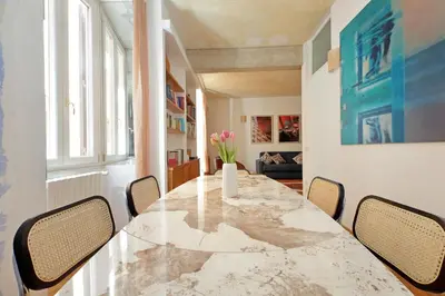 a dining room with a marble table and chairs at Casa Navona - My Extra Home in Rome